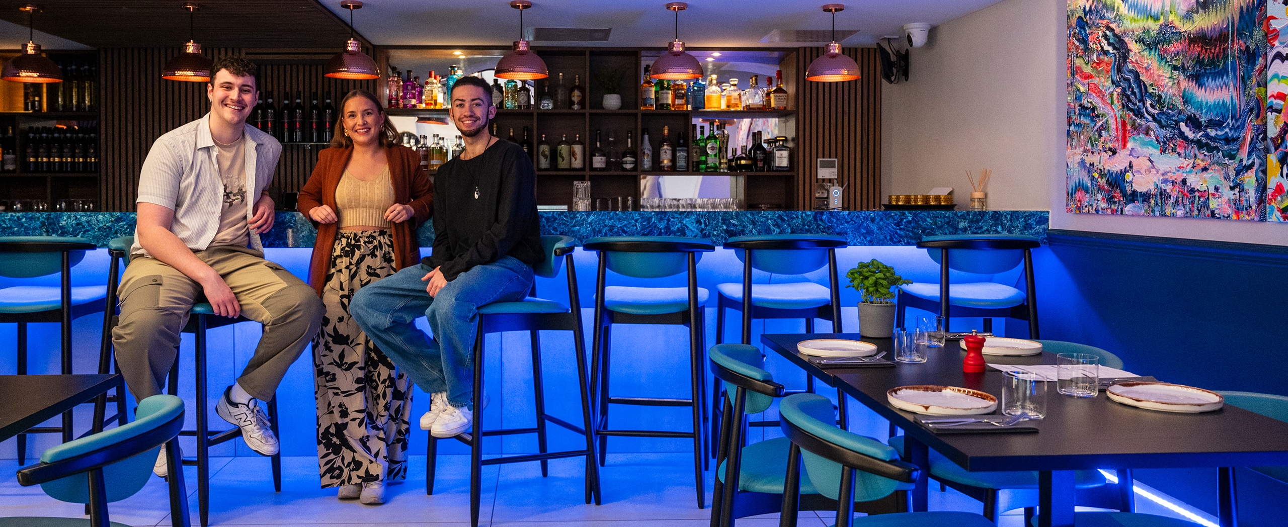 Three members of staff at the bar in a restaurant