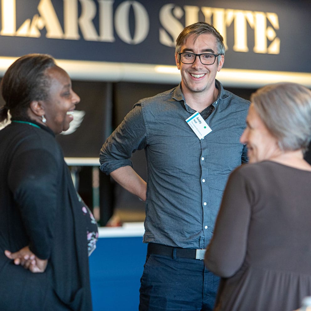 Three people talking at a networking event