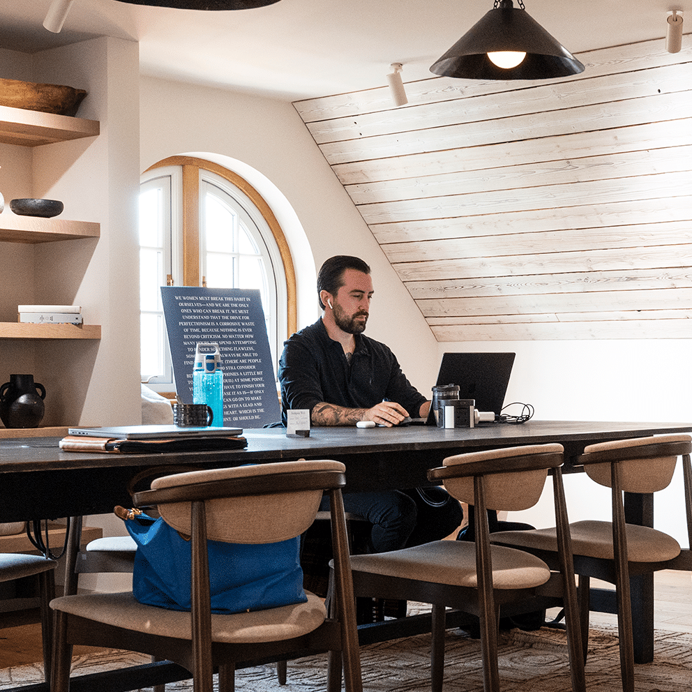 Man working at a table on his laptop at the Boathouse co-working space