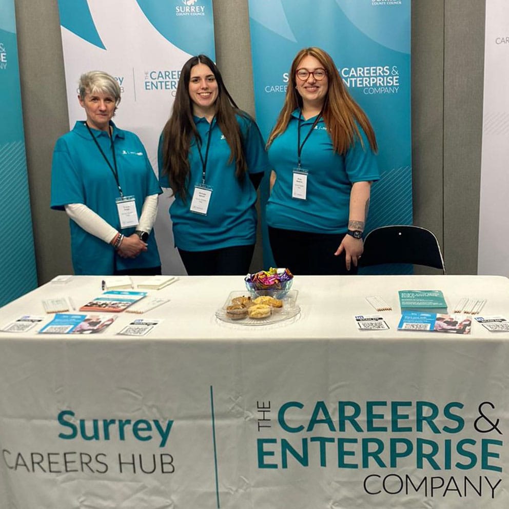 Members of the Surrey Careers Hub team standing in front of pop up banners
